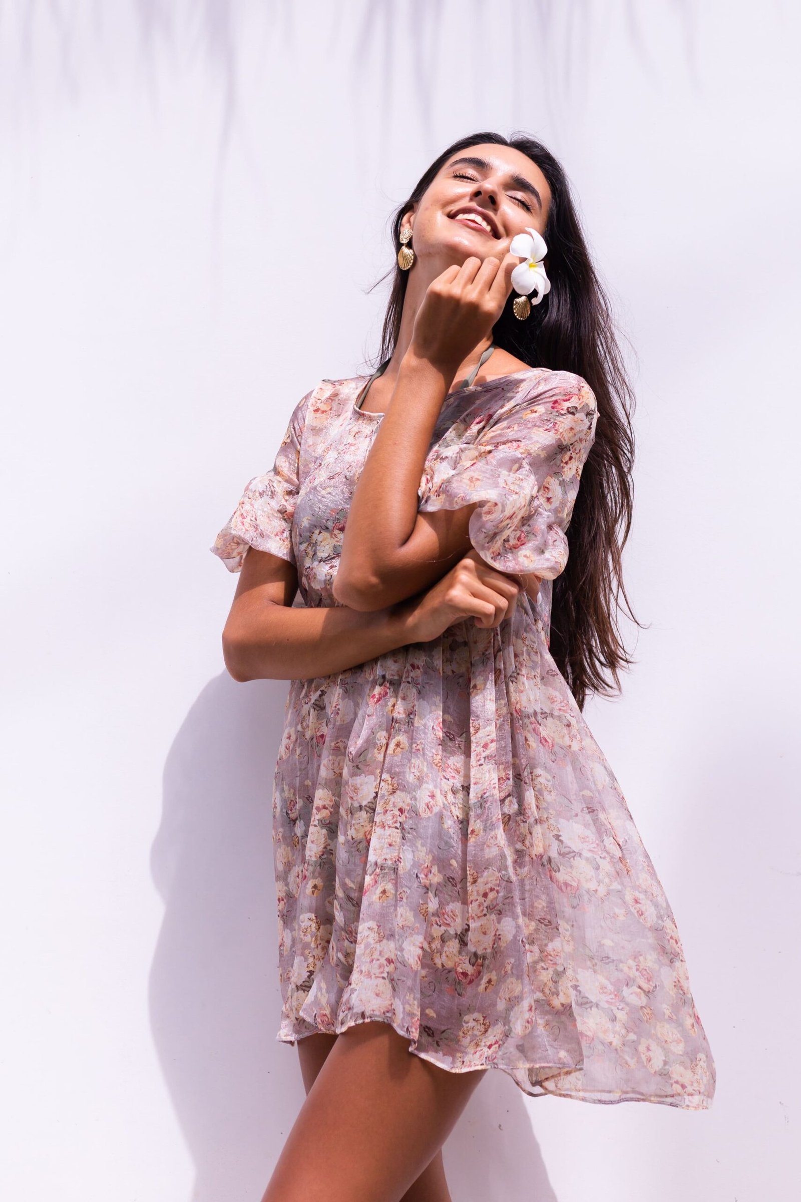 happy-smiling-long-haired-woman-dress-stands-white-wall (1)